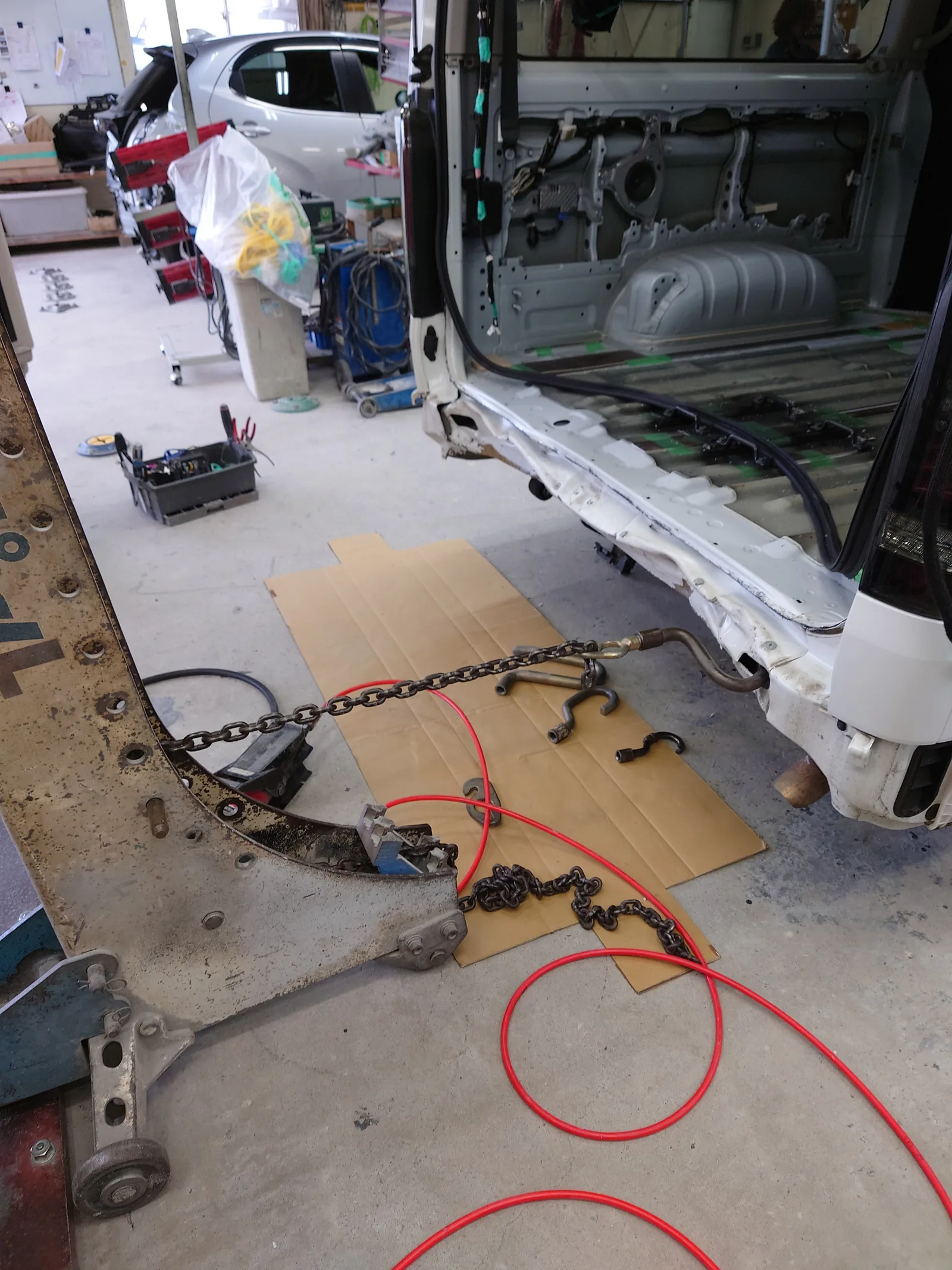 ハイエースの車体後部にチェーンを掛け、変形した部分を引いて形状を戻す