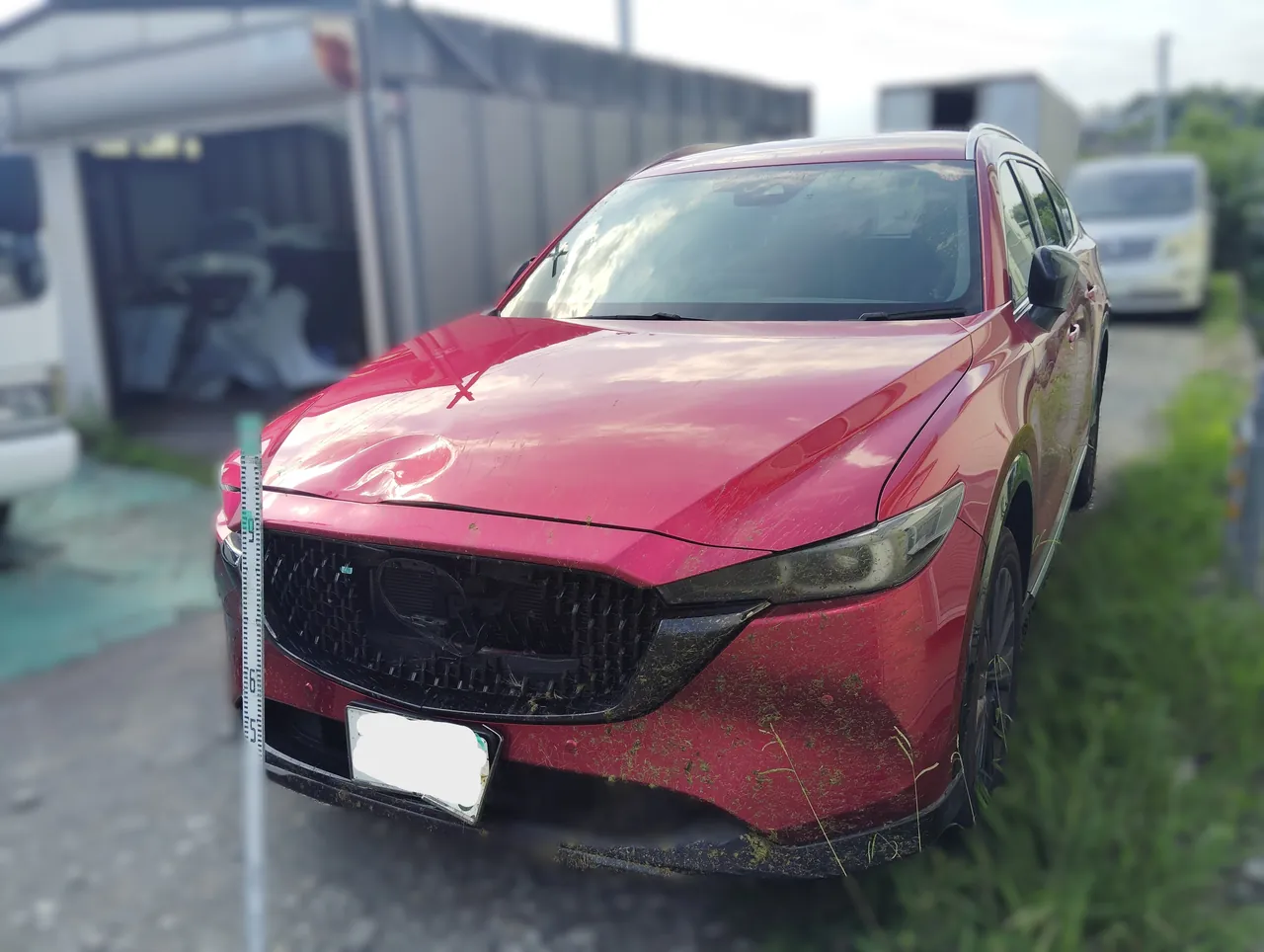 CX-8を左前から。グリルの割れとボンネットのへこみ