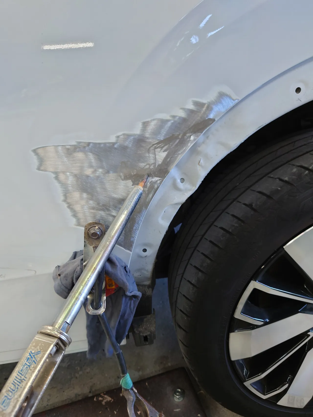 アウトランダーPHEV タイヤまわりの塗装を研いで落とし、へこみを引き出す板金作業
