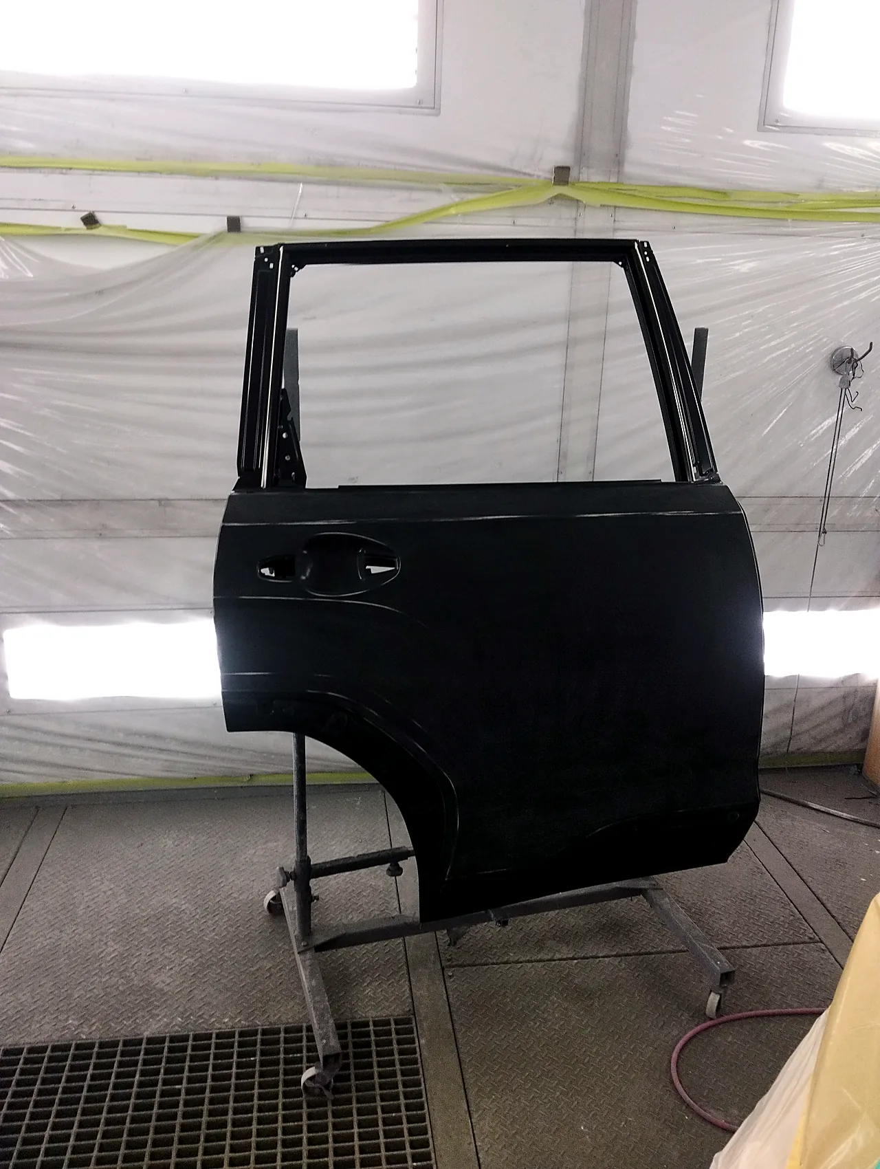 塗装ブースの台に載せた、新型フォレスターの新品の右リヤドア（塗装前）