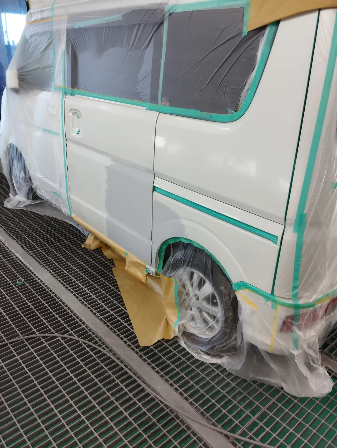 塗装ブースで車全体をビニールで包み、左スライドドアとクォーターを出したエブリイワゴン（塗る前）