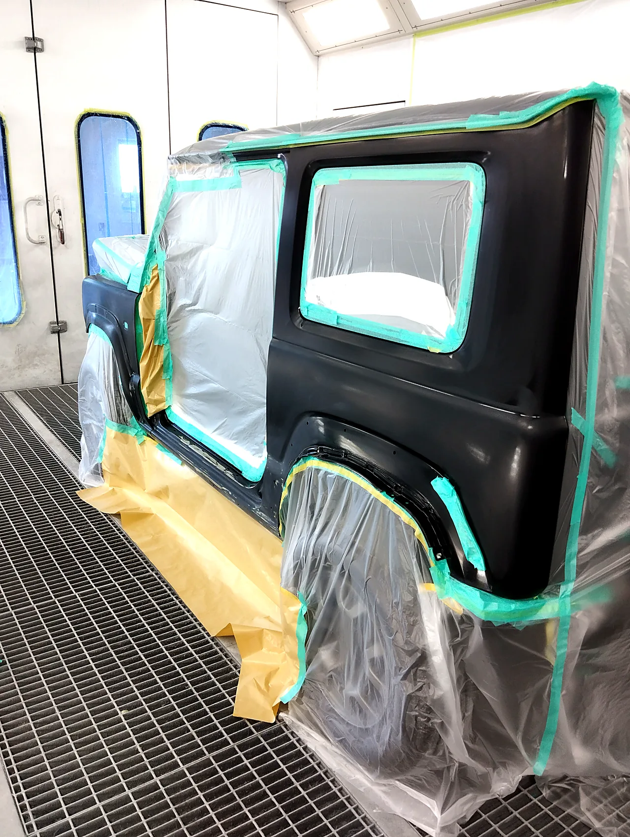 塗装ブースで、屋根の雨どい・窓・後ろの角でテープを切り、左リヤクォーターを出したジムニーシエラ（塗る前）
