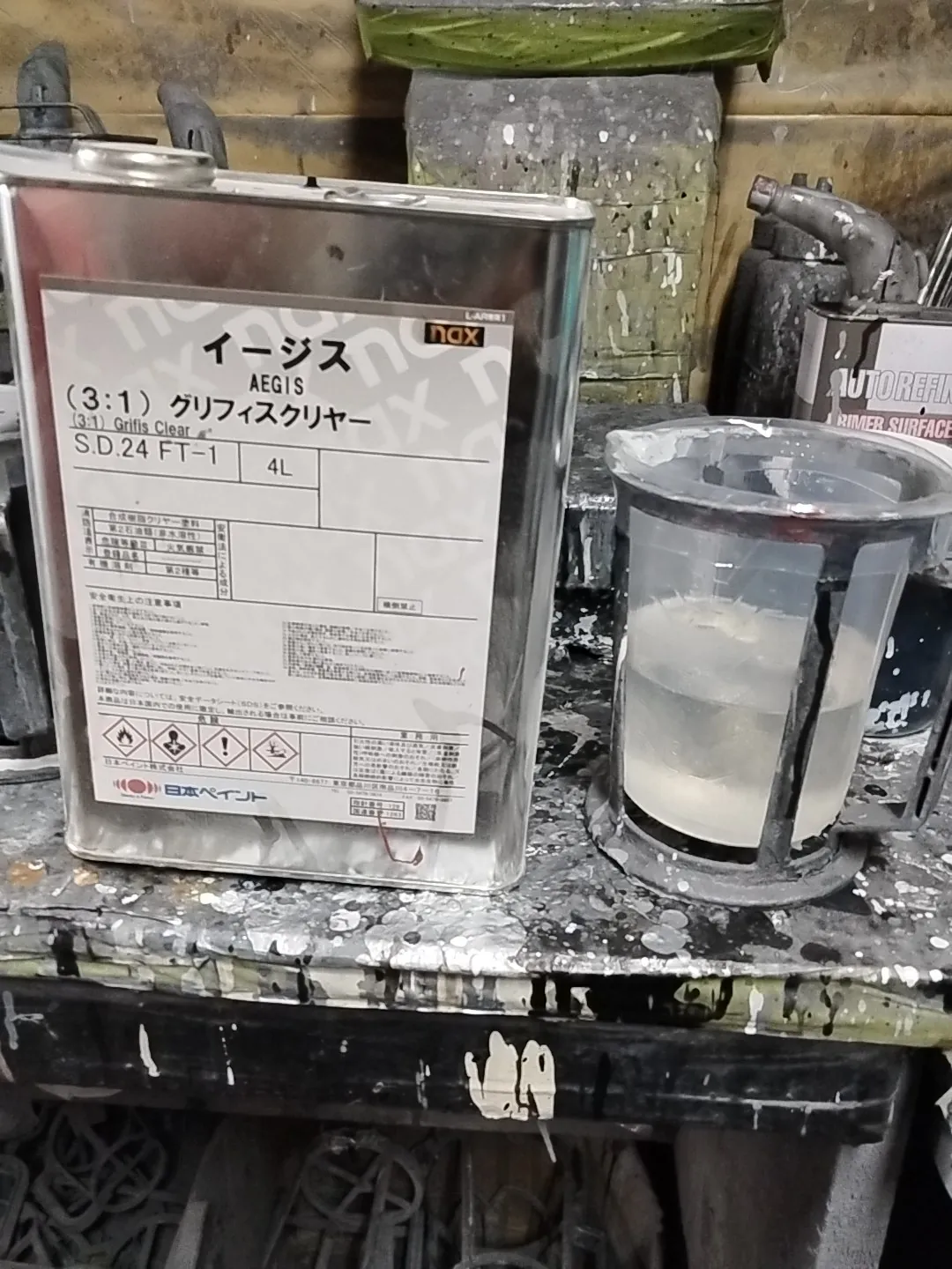 ラベルに「イージス（3:1）グリフィスクリヤー」とある、レクサスNXの塗装で使ったクリヤーの缶と混ぜた容器