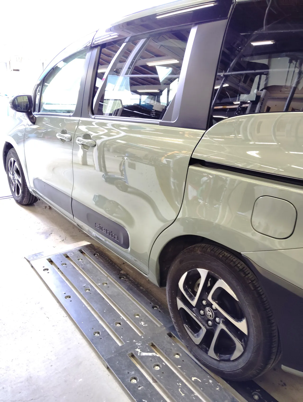 完成したトヨタ シエンタの左側面を後ろ寄りから。左スライドドアと左リヤクォーター(工場内)