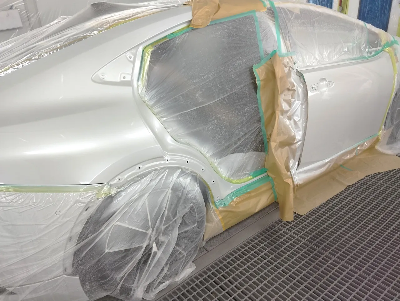 塗装ブースで089の白に塗り終えたプリウスの右側面（右リヤクォーターから右フロントドアまで）