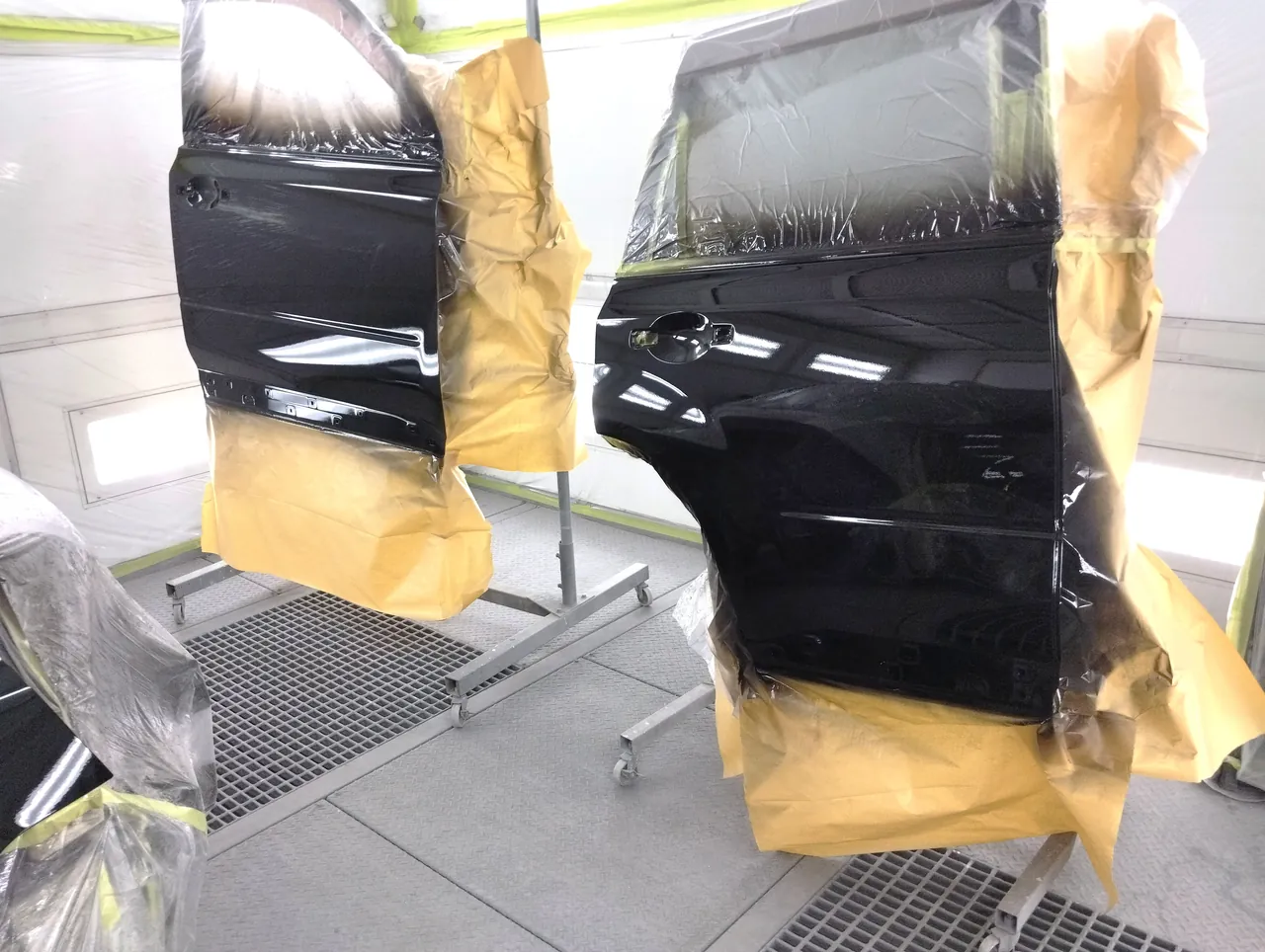 塗装ブースのスタンドで塗り終えた日産 T31エクストレイルの前後のドア（G41の黒）