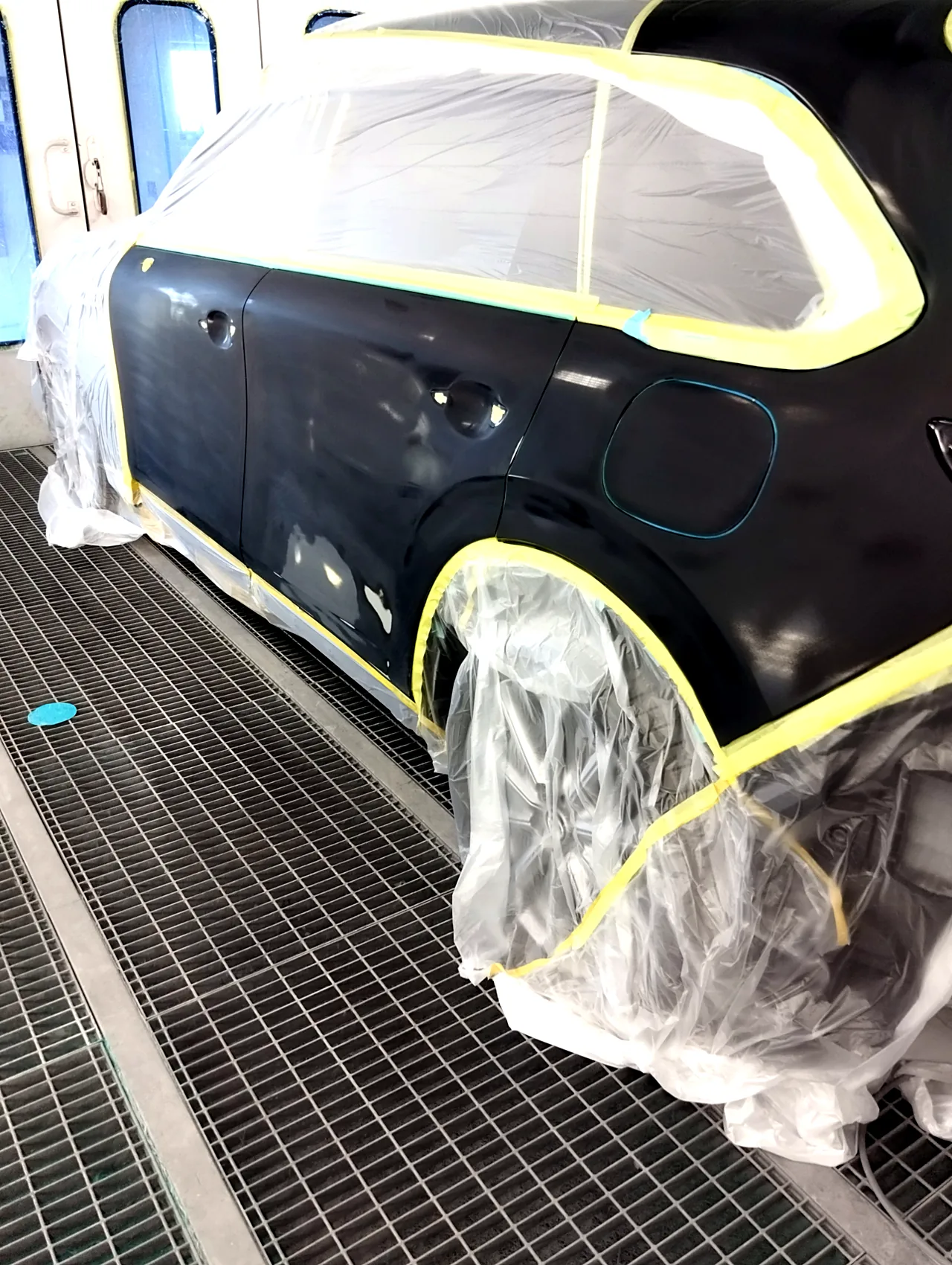 塗装ブースのCX-80の左側面の後ろ側。左リヤドアと、給油口のふたを含む左リヤフェンダーを研いだ状態（塗る前）
