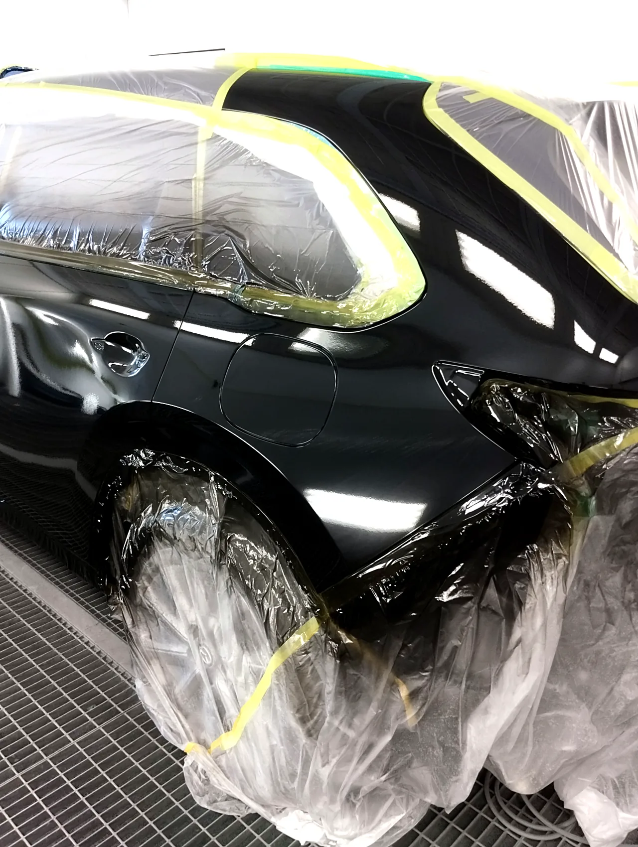 41W ジェットブラックマイカで塗り終えたCX-80の左リヤフェンダーと給油口のふた（塗装ブース）