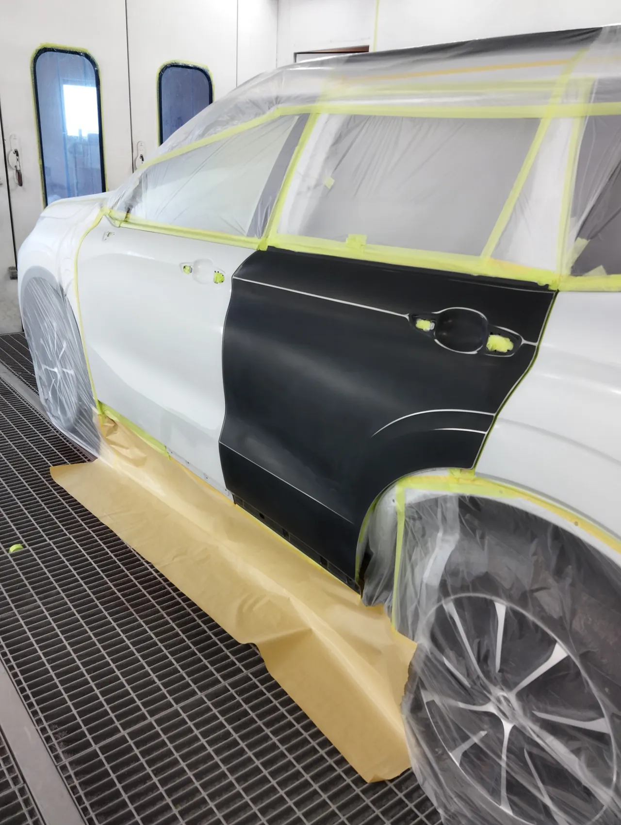 塗装ブースのアウトランダーPHEV。黒い下塗りの新しい左リヤドアの正面（塗る前）
