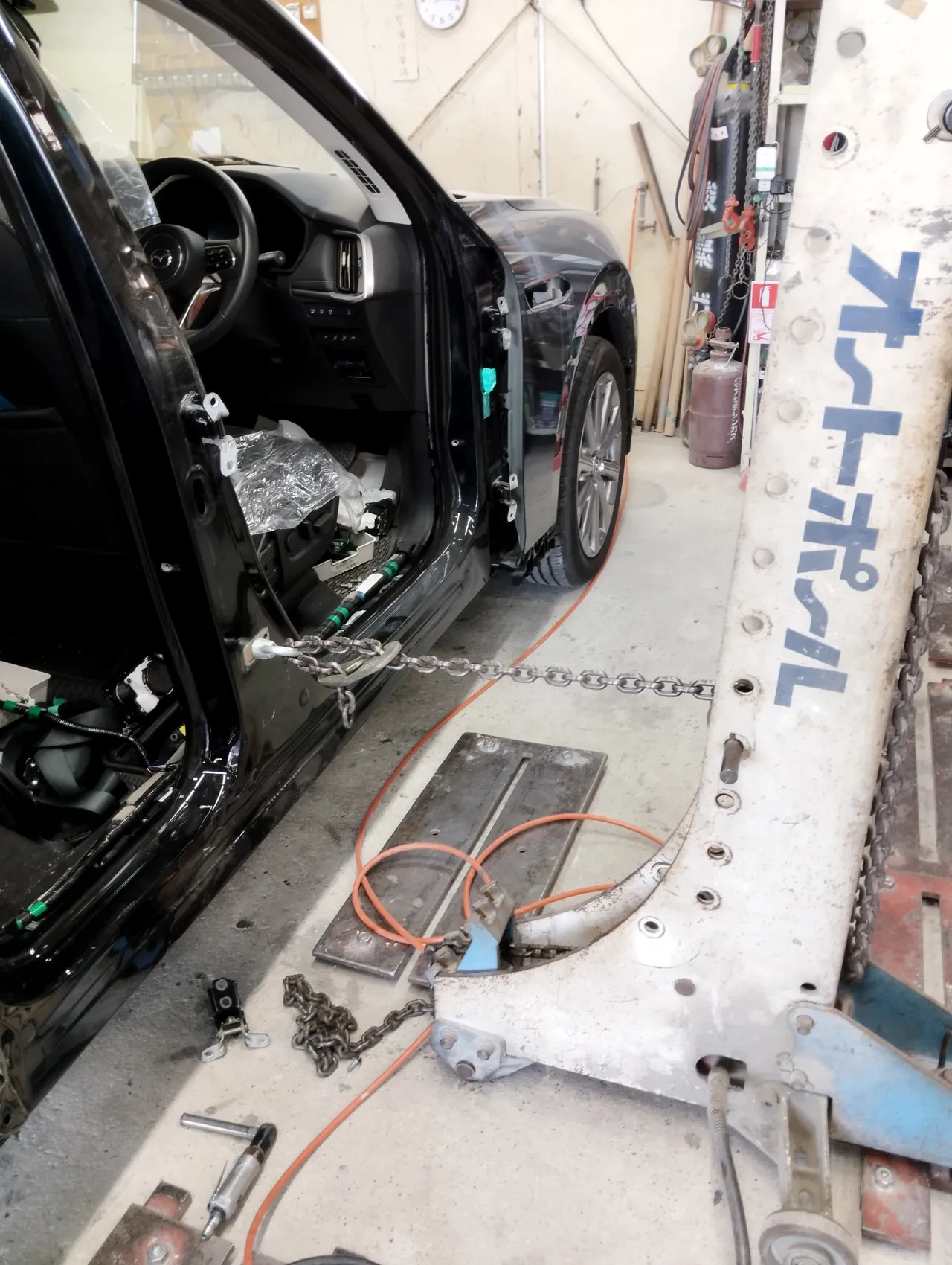 マツダ CX-60の右前ドアを外した開口部。Bピラーの下にフックを掛け、チェーンをオートポール（車体を引く機械）へつなぐ