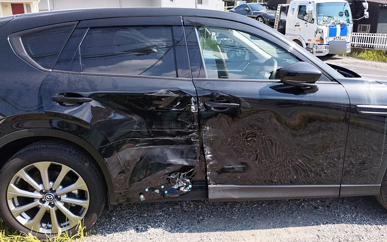 修理前のマツダ CX-60の右側面。前後のドアの境目を中心に大きなへこみ、ドアの下のサイドシルもつぶれる（右の真横から）