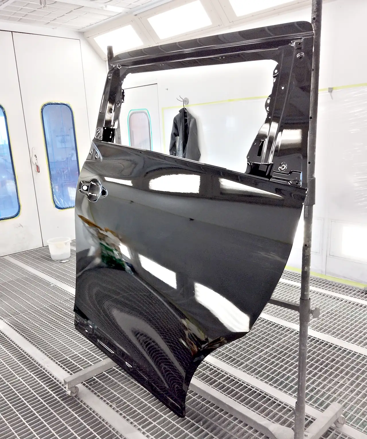 塗装ブースのスタンドの上で、202の黒に塗り上がった40系アルファードの新しい左スライドドア（塗装後）