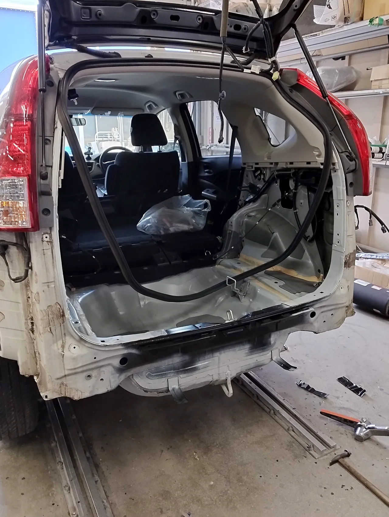 新しいバックパネルを付けたホンダ CR-V の後ろの端。上には、色を塗る前の新しいバックドアを一度付けて開けてある