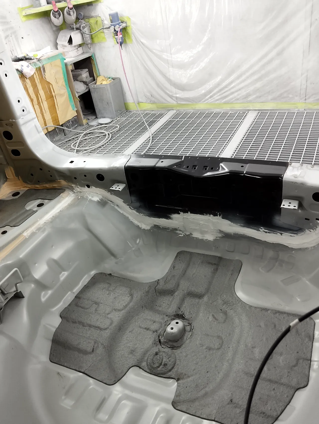 塗装ブースのホンダ CR-V。新しいバックパネルと荷室の床の継ぎ目に塗った白いシーラー