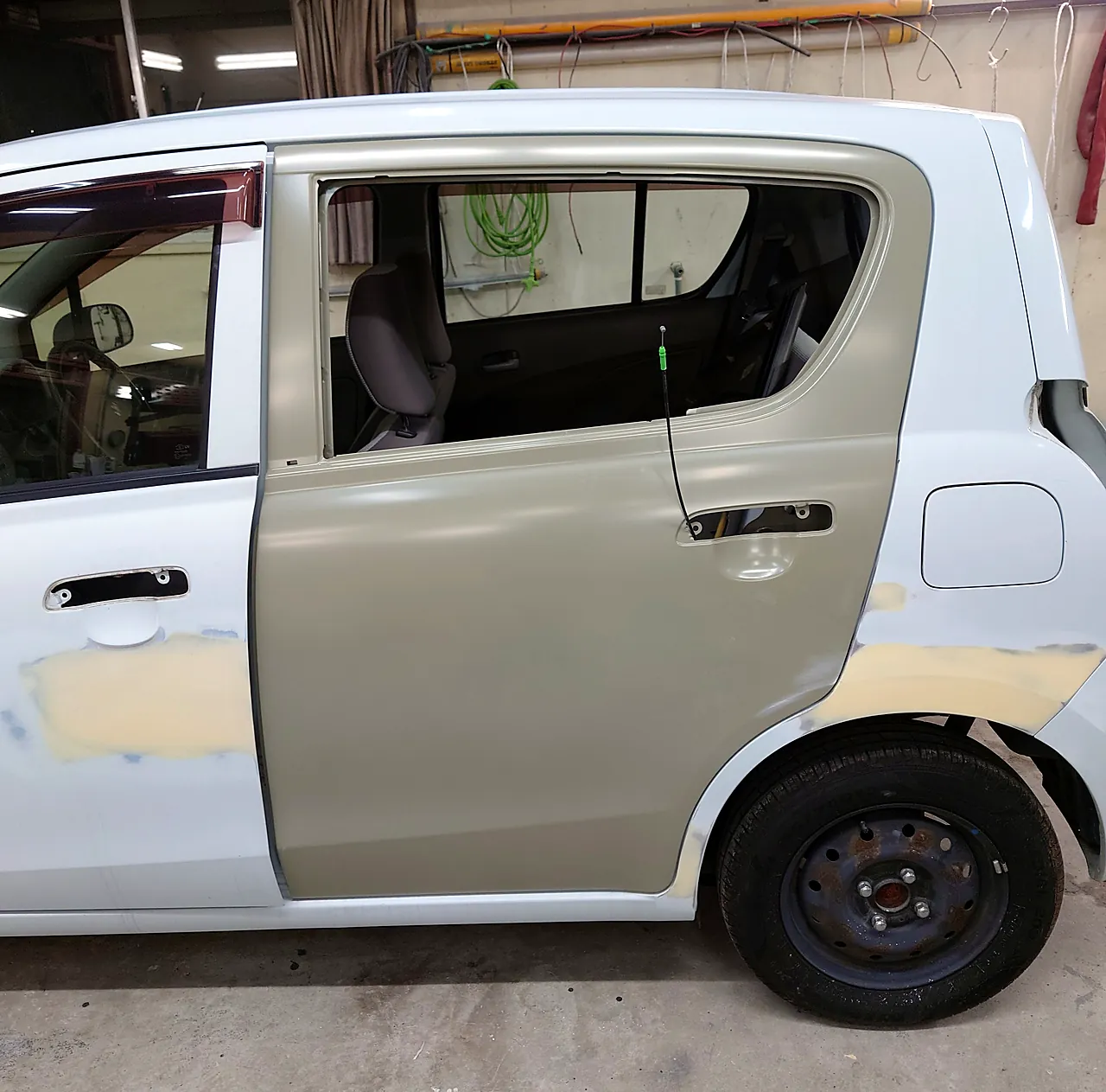 取り寄せた左リヤドアを塗る前に車に付けて合わせた、アルト エコの左側面。前ドアとクォーターにはパテ