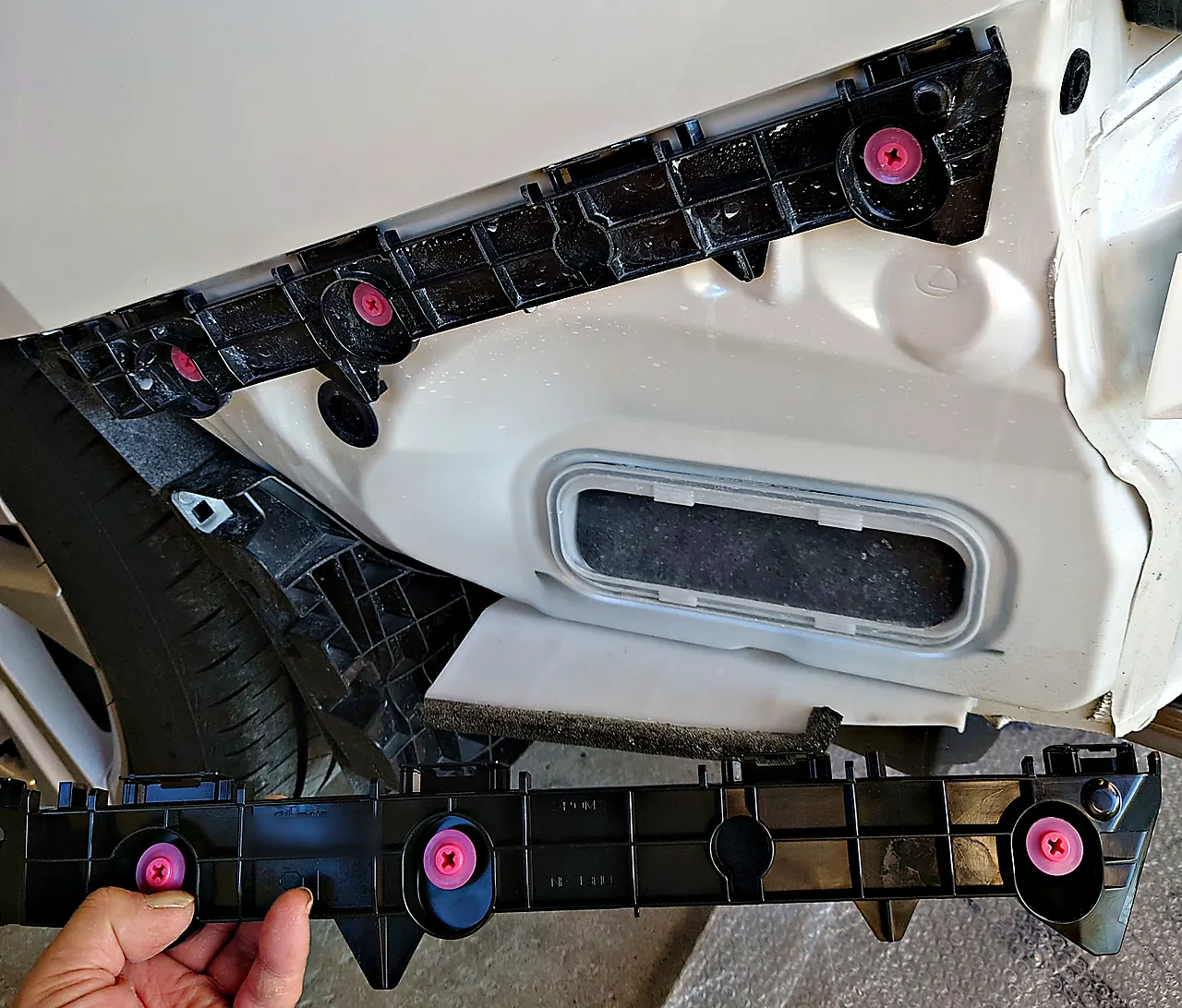レクサスIS 300hの車体に付いた元のリヤバンパーサポート（左）と、その下で手に持った取り寄せたサポート