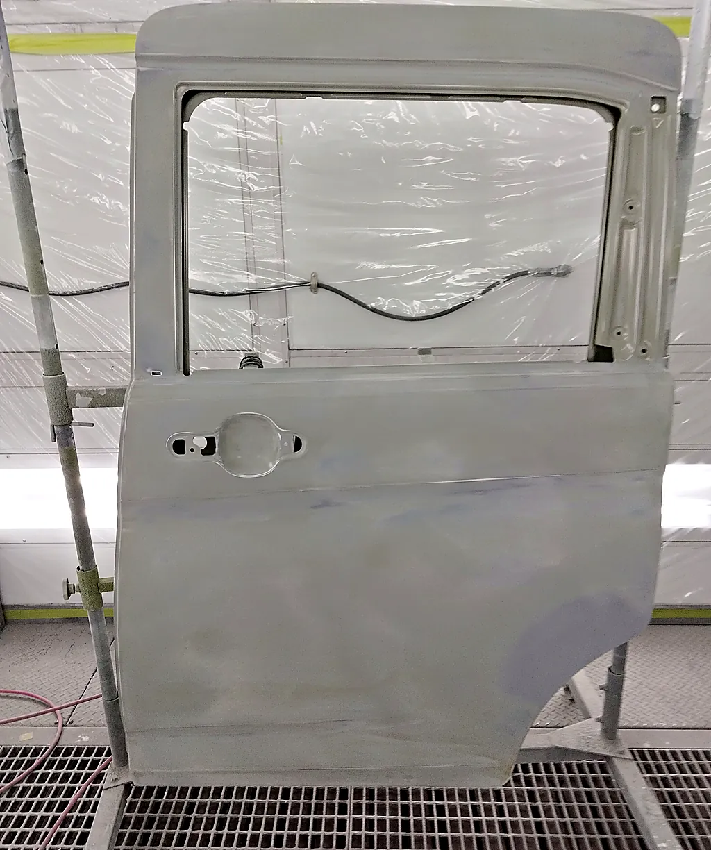 塗装ブースのスタンドに立てた、ソリオ用の新しい左スライドドア（まだ車の色が塗られていない状態）