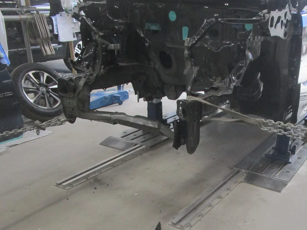フレーム修正機に車体を固定し、チェーンで引いているところ
