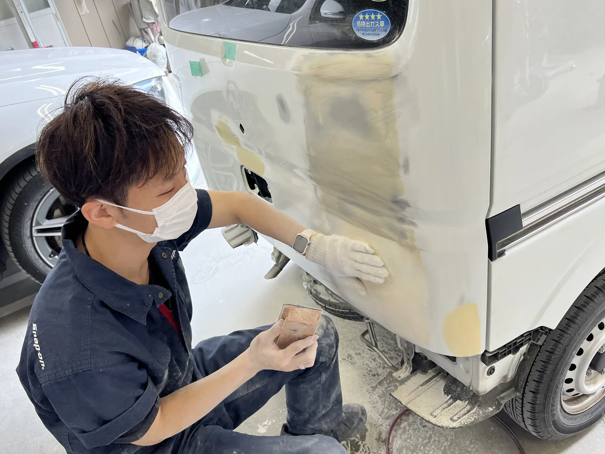 パテを研いで面を出している板金作業の様子