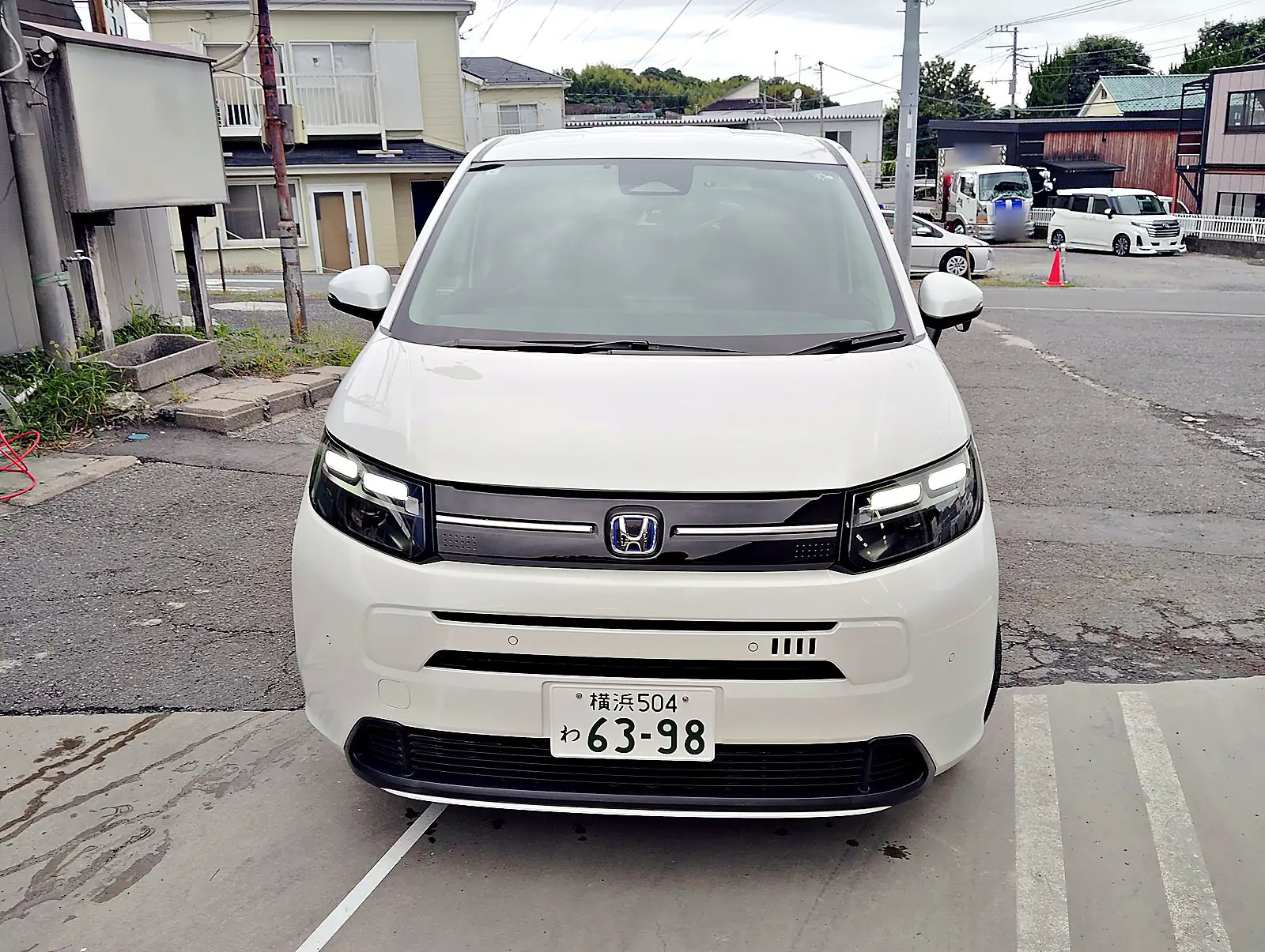 パールホワイトのフリード e:HEV AIR EX を正面から見たところ。この車のわナンバー